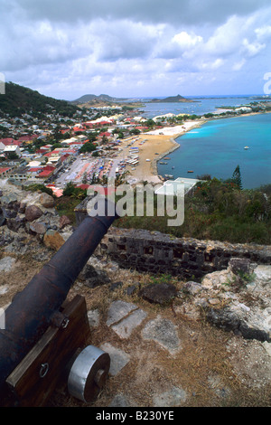 Kanone mit Stadt im Hintergrund an Küste, St. Martin, Guadeloupe, Französische Antillen, kleine Antillen, West Indies Stockfoto
