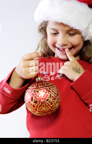 Nahaufnahme des Mädchens Weihnachtskugel halten und Lächeln Stockfoto
