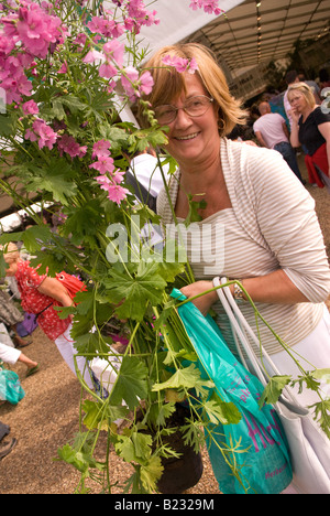 Frau mit ihrem floralen Einkauf bei Hampton Court Flower Show Sonntag, 13. Juli 2008 Stockfoto
