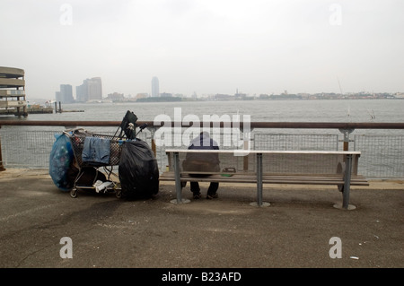 Ein Obdachloser sitzt in Stuyvesant Cove Park in New York NY Stockfoto