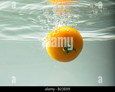 Tomate, die ins Wasser fallen Stockfoto