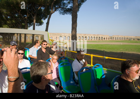 Touristen auf der Archeobus Sehenswürdigkeiten entlang der Via Appia mit Aquädukt im Hintergrund Rom Italien Stockfoto