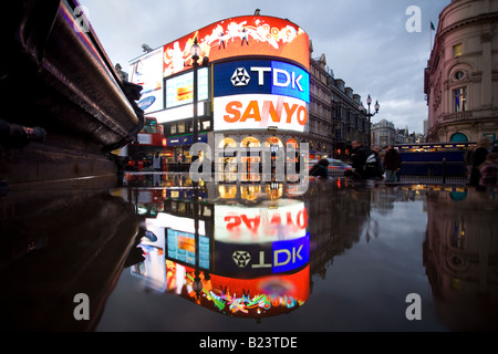 Gebäude reflektieren in den Pfützen nach dem Regen am Piccadilly Circus. Stockfoto