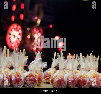 Liebesäpfel zum Verkauf an Kirmes in Zellophan verpackt und mit roten und weißen Twist Krawatten gebunden Stockfoto