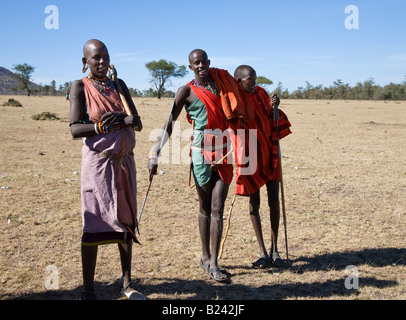 Neugierige junge Massai-Krieger und ein Weibchen in der Nähe ihres Dorfes in der Masai Mara in Kenia Stockfoto