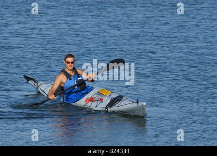 Sportlicher Mann zeigt seine Kajak Fähigkeiten im Mission Bay in San Diego unter einem warmen Licht des späten Sommernachmittag Stockfoto