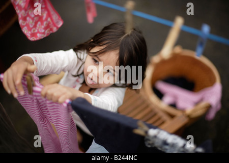 Hängende Wäsche beim Waschen Linie zu trockenen Mädchen im Alter von fünf und Bruder sechs Stockfoto