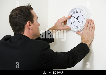 Ein Geschäftsmann die Zeiger einer Uhr einstellen Stockfoto