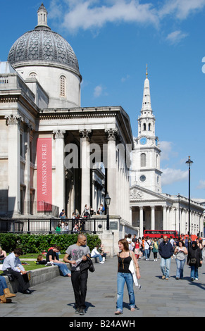 Touristen die Nationalgalerie mit St. Martin s im Bereich Kirche in der Ferne Trafalgar Square in London Stockfoto