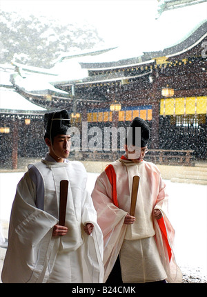 Schneefall hinter zwei Shinto-Priester im Tempel Meiji Jingu - Tokio, Japan Stockfoto