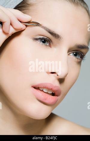 Frau zupfen Augenbrauen Stockfoto