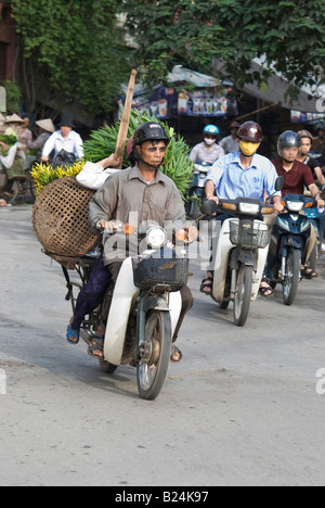 Motorradfahrer kommen hinunter einen Hügel in Hanoi Vietnam Stockfoto