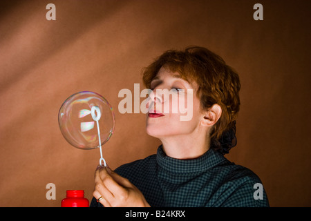 Frau mittleren Alters Seifenblasen Modell veröffentlicht Stockfoto