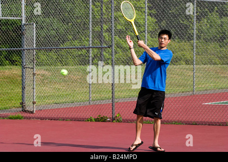 Junge asiatische Mann Tennis spielen Stockfoto