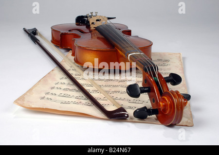 Alte Geige und Vintage Musik über einen neutralen Hintergrund Stockfoto