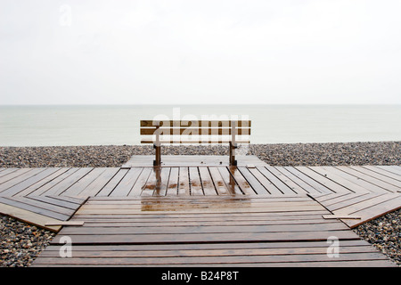 Eine leere Bank im Regen mit Blick aufs Meer in der Nähe von St Valery Sur Somme Frankreich Stockfoto