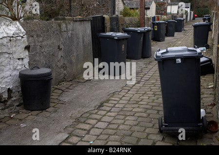 fahrbare Mülltonnen abholbereit in einer hinteren Kopfsteinpflaster Ginnel in einer Stadt in Nordengland Stockfoto