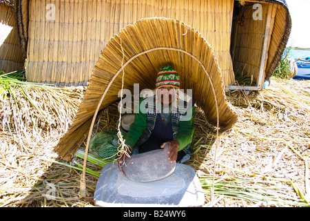 Mann, Schleifen mit einem Stein Uros Reed schwimmende Insel auf See Titicaca Puno, Peru Stockfoto