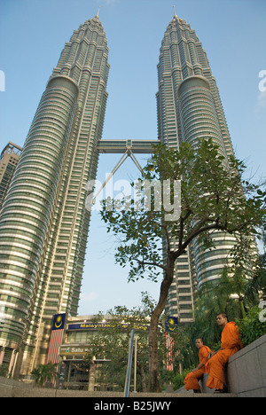 Zwei buddhistische Mönche Ruhe unter einem Baum in der Nähe die Petrona Twin Towers in Kuala Lumpur, Malaysia Stockfoto