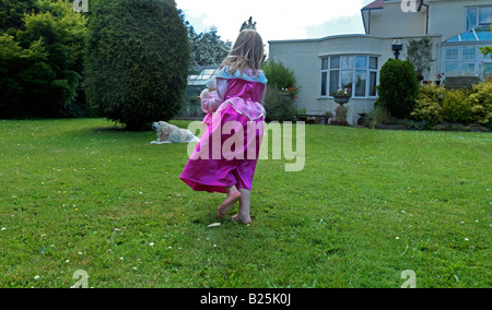 Mädchen gekleidet als Prinzessin mit einer Prinzessin Bär in Ein Garten in Surrey England Stockfoto
