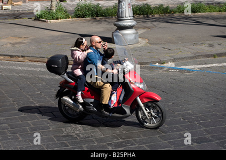 Mann fährt Motorrad mit seinen Kindern und Gespräche auf dem Handy in Catania, Sizilien, Italien Stockfoto