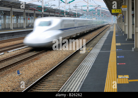 Japanische Hochgeschwindigkeitszug (Shinkansen), die durch ein Bahnhof. Stockfoto