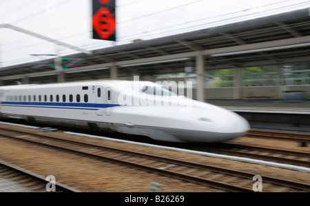 Ein japanischer Bullet Train (Shinkansen), der durch einen Bahnhof fährt Stockfoto