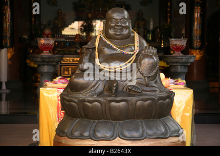 Ein lachender Buddha-Statue am Eingang zu einem buddhistischen Tempel in Singapurs Chinatown. Stockfoto