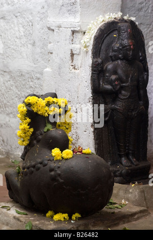 Eine bekränzten Nandi-Statue und eine geformte Statue aus Stein in einem der Tempel mit dem Heiligen Lingam am Talakkad in Karnataka Stockfoto