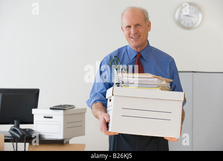 Leitenden Geschäftsmann mit Box und Bürobedarf Stockfoto