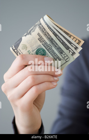 Geld in Frauenhand Stockfoto