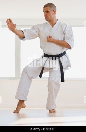 Hispanische männlichen Karate Schwarzgurt im Kampf gegen die Haltung Stockfoto