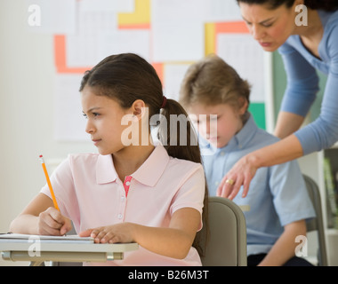 Hispanischen Mädchen schreiben an Schulbank Stockfoto