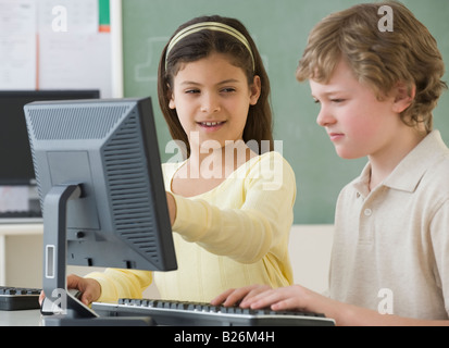 Multi-ethnischen Schulkinder Blick auf Computern Stockfoto