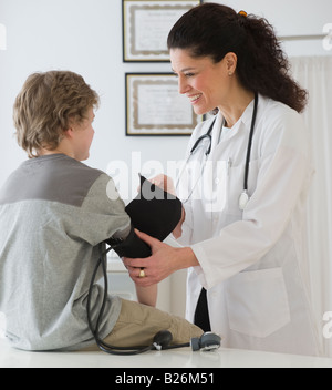 Hispanische Ärztin die Kindes-Blutdruckmessung Stockfoto
