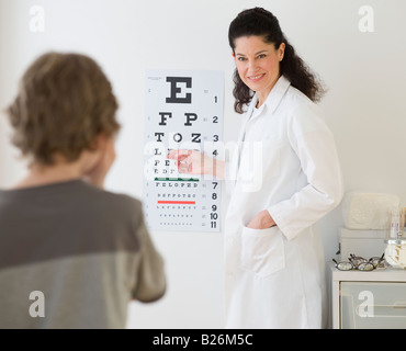 Hispanische Ärztin zeigte auf der Sehtafel für Kind Stockfoto