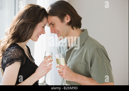 Paar mit Champagner und Stirnen berühren Stockfoto