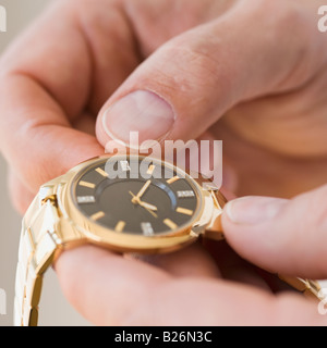 Nahaufnahme des Mannes aufziehen Uhr Stockfoto
