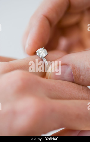 Putting Verlobungsring am Finger Frau Mann Stockfoto