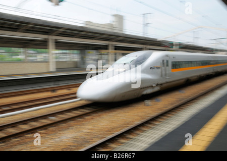 Japanische Hochgeschwindigkeitszug (Shinkansen), die durch ein Bahnhof. Stockfoto