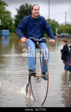 TEWKESBURY RESIDENT GRAHAM WEATHERLY REITET AUF SEINEM HOCHRAD DURCH DAS WASSER WÄHREND DES HOCHWASSERS IN GLOUCESTERSHIRE JULI 2007 U Stockfoto