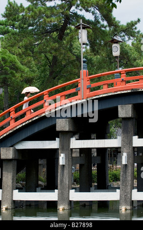 Person, die Überquerung der berühmten Zinnoberrot gewölbte Brücke namens Taikobashi am Sumiyoshi Taisha Shrine in Osaka Stockfoto