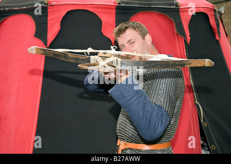 Reenactor aus dem 11.. Jahrhundert vor dem roten Zelt mit einer Rampart-Armbrust bei der Veranstaltung der Scottish Historical Saltyre Society in Fort George, Ardersier, Schottland. Stockfoto