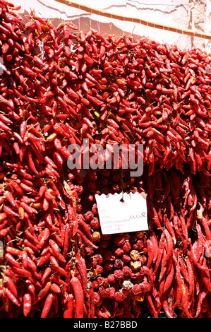 Rote Chilis hängen für den Verkauf außerhalb ein Gemüseladen in Italien Stockfoto