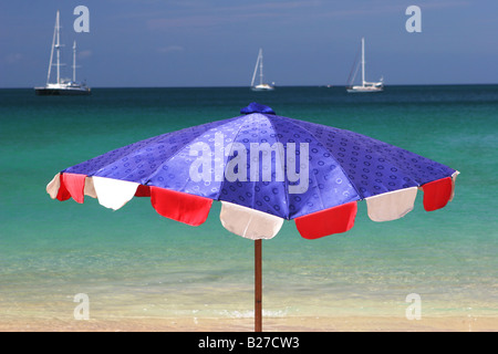 Helles Blau und rot Sonnenschirm mit Blick auf das Meer an einem Sommertag. Stockfoto