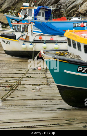 Bunte Fischerboote vertäut in einem Hafen bei Ebbe in der Stadt von Newquay England Angeln cornish Stockfoto