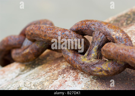 Eine Makro Nahaufnahme einer rostigen Kette hängen über den Rand der Hafenmauer erschossen in der Cornish Angeln Stadt von Newquay England Stockfoto