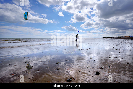 Kitesurfer am Goring Strand in der Nähe von Worthing Silhouette gegen den Himmel und Strand Reflexion. Bild von Jim Holden. Stockfoto