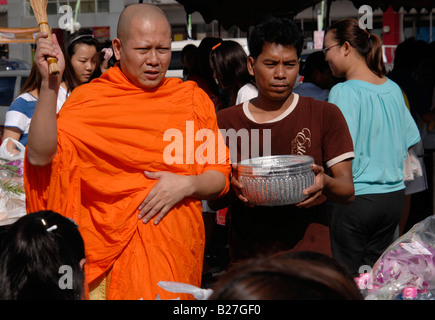 Mönch auf seine Almosen Runde begleitet von Tempel Boy halten Almosenschale, Bangkok, thailand Stockfoto