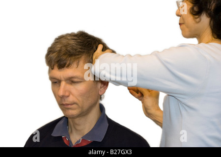 Akupunktur-Behandlung - Ärztin Akupunkturnadeln hinter einem Mann Ohr anwenden Stockfoto